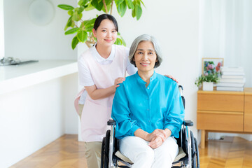 Fototapeta premium 車椅子に乗った女性をサポートする介護士