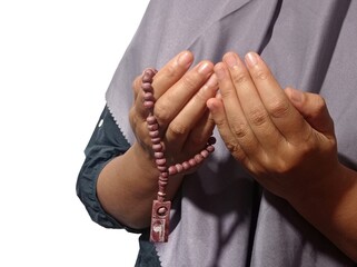 Muslim woman praying holding prayer beads