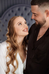 A man and a woman in silk pajamas in the bedroom. 