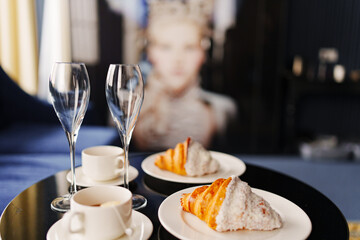 croissants, cups of coffee and empty wine glasses on the table. 