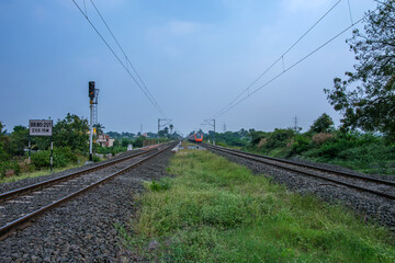 Saffron coloured Vande Bharat Express near Pune India. This is a tri-weekly train between Pune and Kolhapur and also a tri-weekly train between Pune and Hubballi.