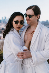 Stylish Couple in Cozy Robes Enjoying Beautiful Urban Views Together