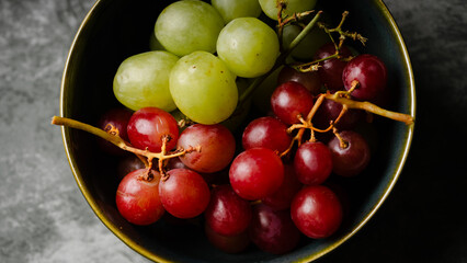 Close-Up of Fresh Green and Red Grapes in a Dark Bowl