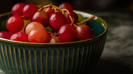 Close-Up of Fresh Green and Red Grapes in a Dark Bowl