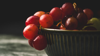 Close-Up of Fresh Green and Red Grapes in a Dark Bowl