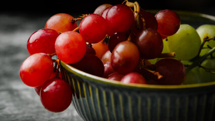 Close-Up of Fresh Green and Red Grapes in a Dark Bowl