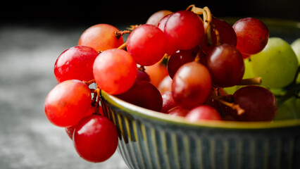 Close-Up of Fresh Green and Red Grapes in a Dark Bowl