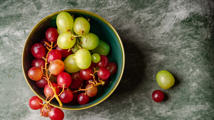 Close-Up of Fresh Green and Red Grapes in a Dark Bowl