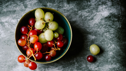 Close-Up of Fresh Green and Red Grapes in a Dark Bowl