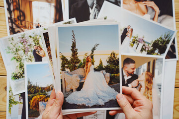 Men's hands put on the table and show wedding photos.