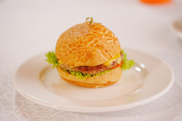 Mini burger with patty, cheese, tomato and lettuce. 