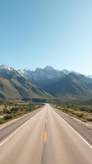 Fototapeta premium Empty highway cutting through beautiful mountain landscape under clear blue sky, route