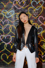 Fashion model posing confidently against a vibrant and colorful graffiti