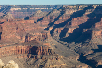 Incredible light and shadow play in between amazing rock formations, captured during sunrise from Mother Point, in South Rim of Grand Canyon National Park, Arizona. High quality picture for download.