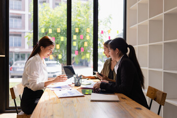 Asian businesswoman teamwork working on laptop with finances analysis report at desk in office,...