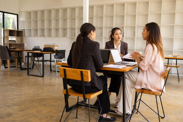Technology and financial advisory services concept. Businesswoman teamwork and working on digital laptop computer with advisor showing plan of investment to clients at table office. Digital marketing.