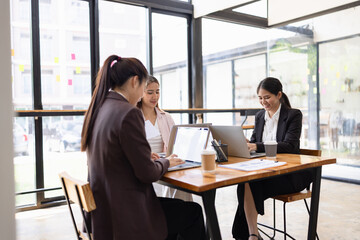 Technology and financial advisory services concept. Businesswoman teamwork and working on digital laptop computer with advisor showing plan of investment to clients at table office. Digital marketing.