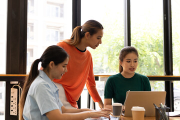 Fototapeta premium group of asian businesswoman working on laptop with finances analysis report at desk in office, business financing, accounting banking, Team of creative and business planning, 