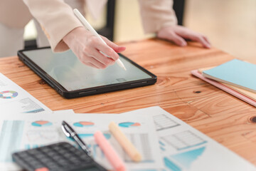 Professional using tablet for business analysis and data visualization in a modern workspace