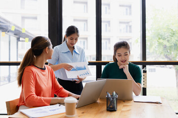 Obraz premium group of asian businesswoman working on laptop with finances analysis report at desk in office, business financing, accounting banking, Team of creative and business planning, 