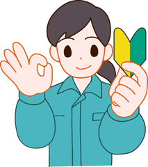 作業服を着た初心者マークを持ちOKサインをしている笑顔のデフォルメ女性のイラスト