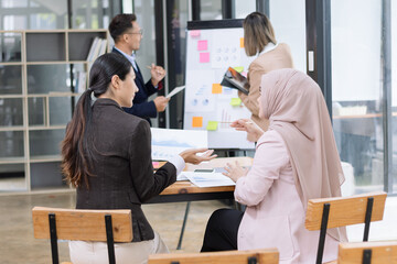 Obraz premium Team of Asian business people and working together in office, Startup projects and business presentation at meeting room.