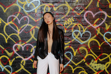 Fashion model posing confidently against a vibrant and colorful graffiti
