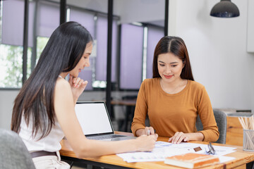 Obraz premium Asian businesswoman working on laptop with finances analysis report at desk in office, business financing, accounting banking,