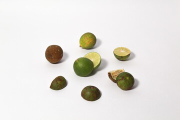 Green lime fruits on isolated white background. Sliced and unsliced.