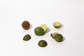 Green lime fruits on isolated white background. Sliced and unsliced.