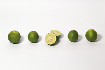 Green lime fruits on isolated white background. Sliced and unsliced.