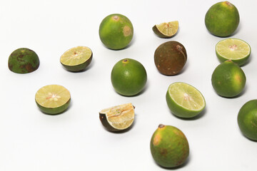 Green lime fruits on isolated white background. Sliced and unsliced.