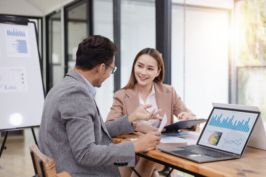 Two business people working with business financing accounting banking and laptop with finances analysis report at desk in office. 
