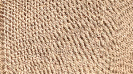 Close view of a piece of used brown burlap cloth.. Burlap background and texture