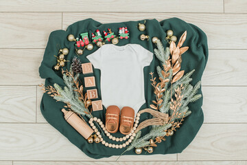 Festive baby announcement setup featuring a baby onesie, a letterboard, and seasonal holiday...