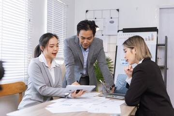 Asian business teamwork working on digital tablet with analysis report and advisor showing plan, Financial analysis and Marketing teamwork concept.