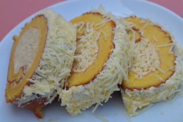 Cheese rolled sponge cake overflowing with cheese, close-up.