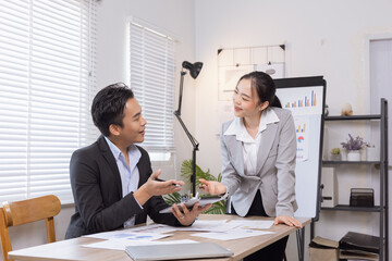 Two business people working with business financing accounting banking and laptop with finances analysis report at desk in office. 