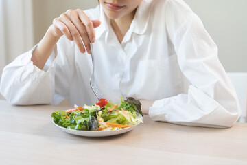 Diet in bored face, unhappy beautiful asian young woman, girl on dieting, holding fork at tomato on salad plate, dislike or tired with eat fresh vegetables. Nutrition of clean, healthy food good taste