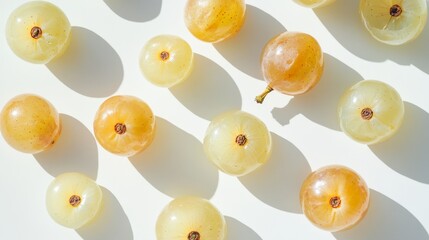 Fototapeta premium An assortment of whole and cut Shine-Muscat grapes arranged on a white surface. Close-up view of white Japanese grapes, showing their delicate skin and translucent flesh.