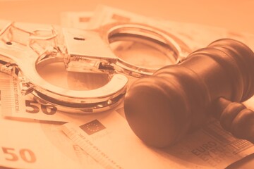 Law gavel with euros and handcuffs, close up.
