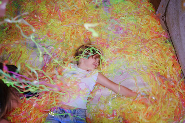 Cheerful teen girl with blonde short hair at a party with colorful confetti