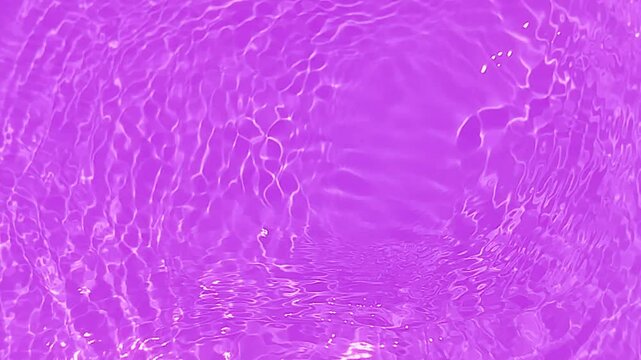 Purple water splashes on the surface ripple blur. Defocus blurred transparent pink colored clear calm water surface texture with splash and bubble. Water waves with shining pattern texture background