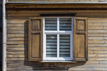 The wooden shutters of a window are wide open, revealing a bright, cheerful interior.