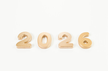 2026 Happy New Year. Top view of gold numbers on white background. Copy space, flat lay.