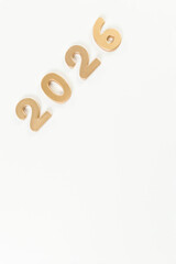 2026 Happy New Year. Top view of gold numbers on white background. Copy space, flat lay.