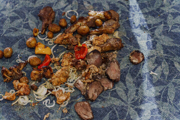 Food on the floor. Meat and vegetables fell on the carpet in the restaurant.