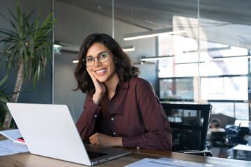 Portrait 30s latin hispanic business woman manager working on laptop computer in modern office....