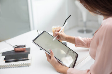 Closeup shot of business woman's hand using pen and writing in computer notebook business calculations or a female student using a computer The phone works for
 Exam preparation, presentations