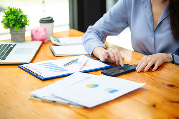 Closeup shot of business woman's hand using pen and writing in computer notebook business calculations or a female student using a computer The phone works for
 Exam preparation, presentations